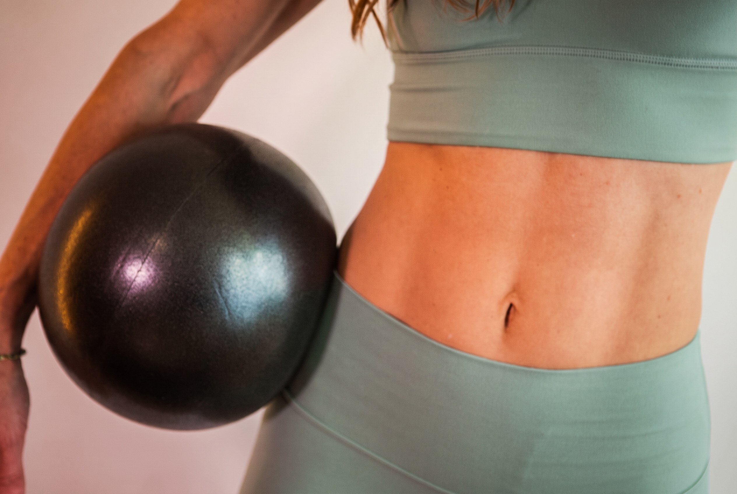 Kate holding a Pilates ball during her practice